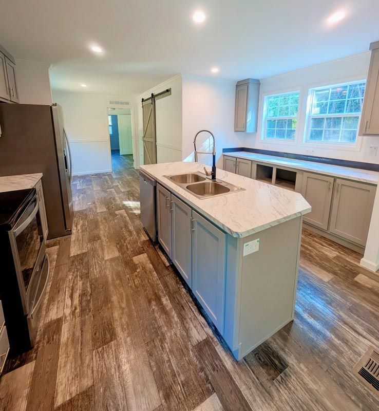 Bright modern kitchen with white cabinets, marble island, and wood-look floors