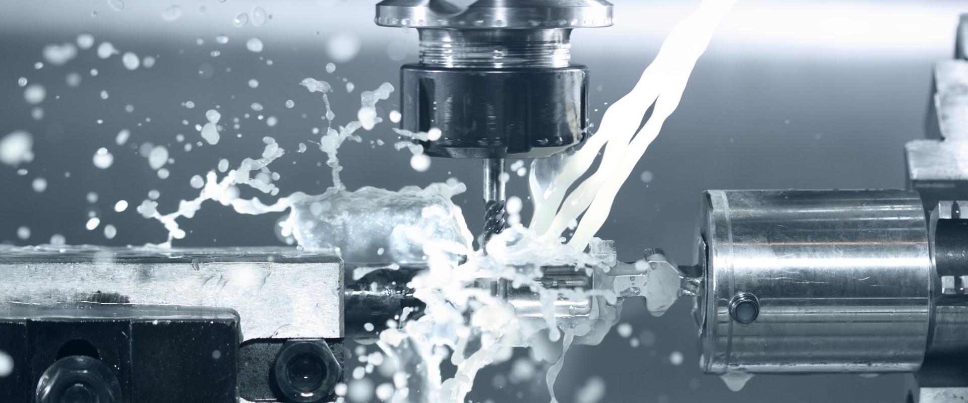 Eine Maschine schneidet ein Stück Metall, aus dem eine Flüssigkeit austritt.