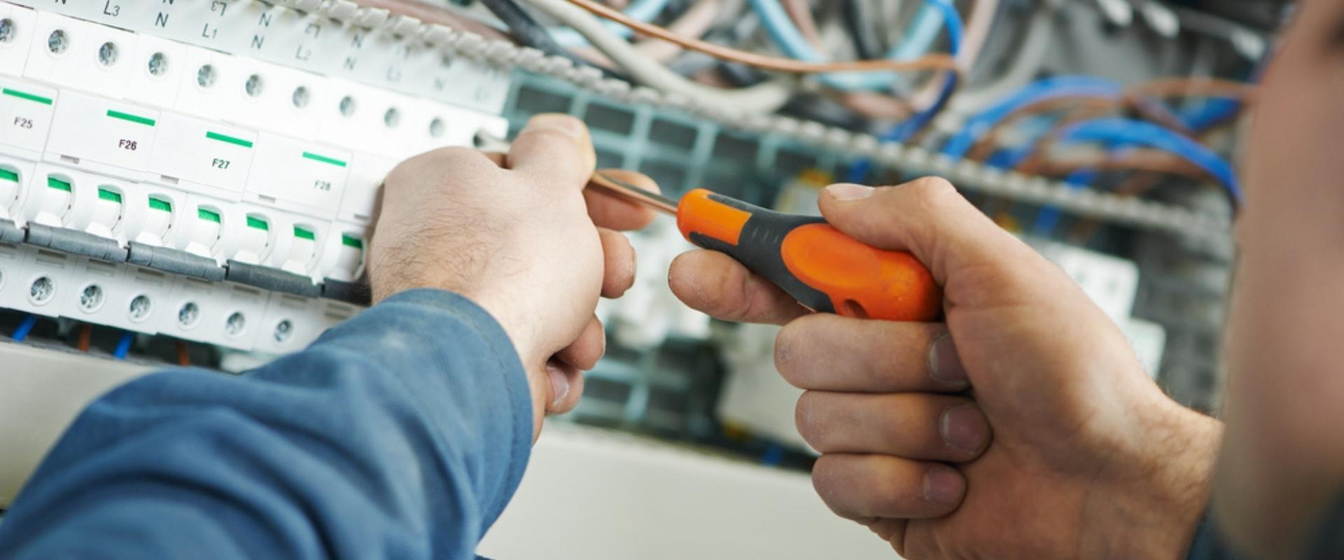 Ein Elektriker arbeitet mit einem Schraubenzieher an einer Platine.
