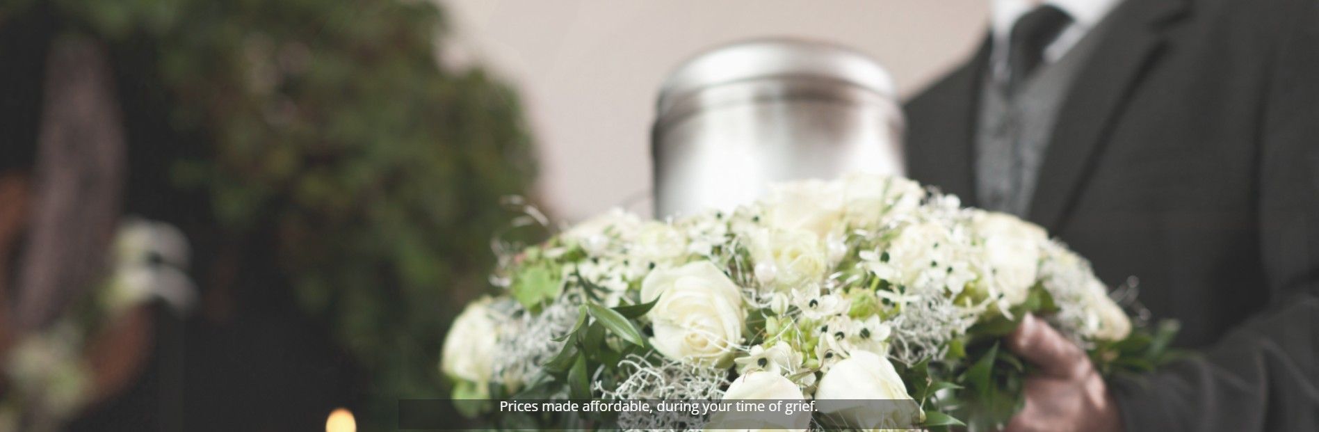 Wedding bouquet of white flowers held in front of a silver urn