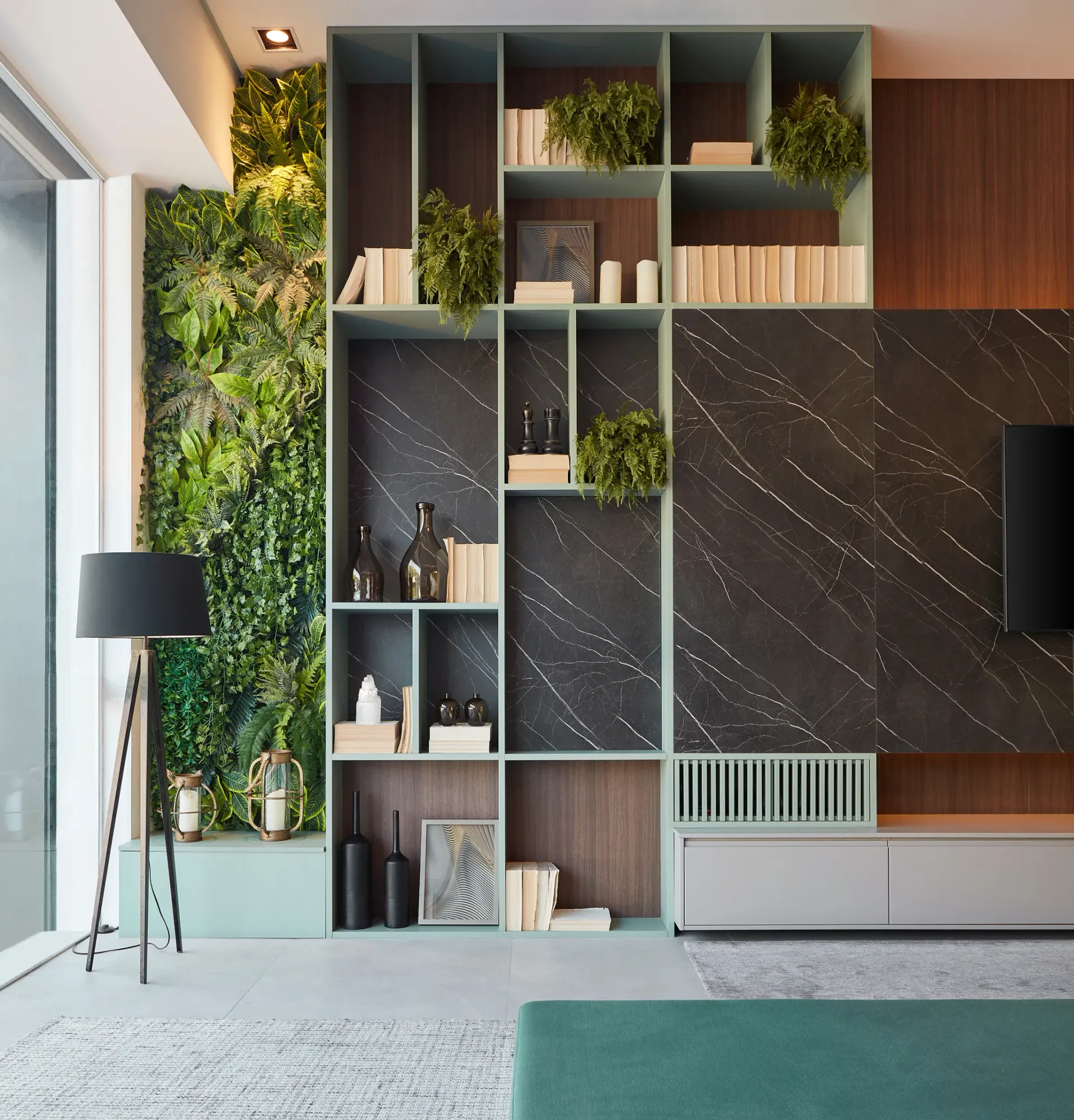 Salón moderno con estanterías empotradas, paneles de pared de mármol oscuro, plantas de interior y una lámpara de pie junto a grandes ventanales.