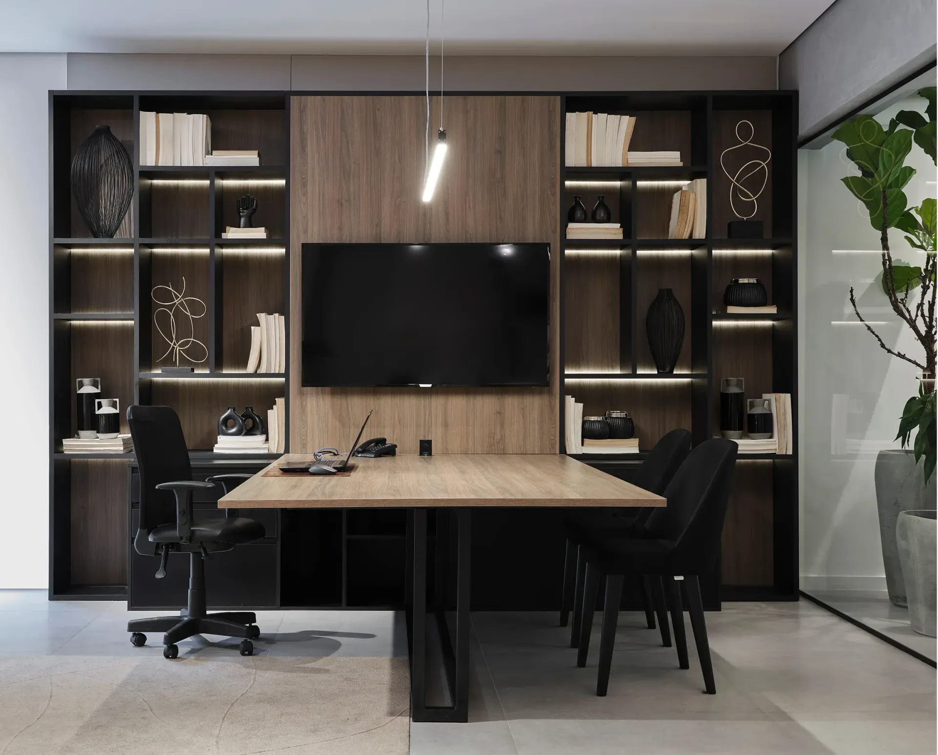 Oficina en casa moderna con estanterías de madera, televisor montado en la pared, escritorio y dos sillas en un interior elegante.