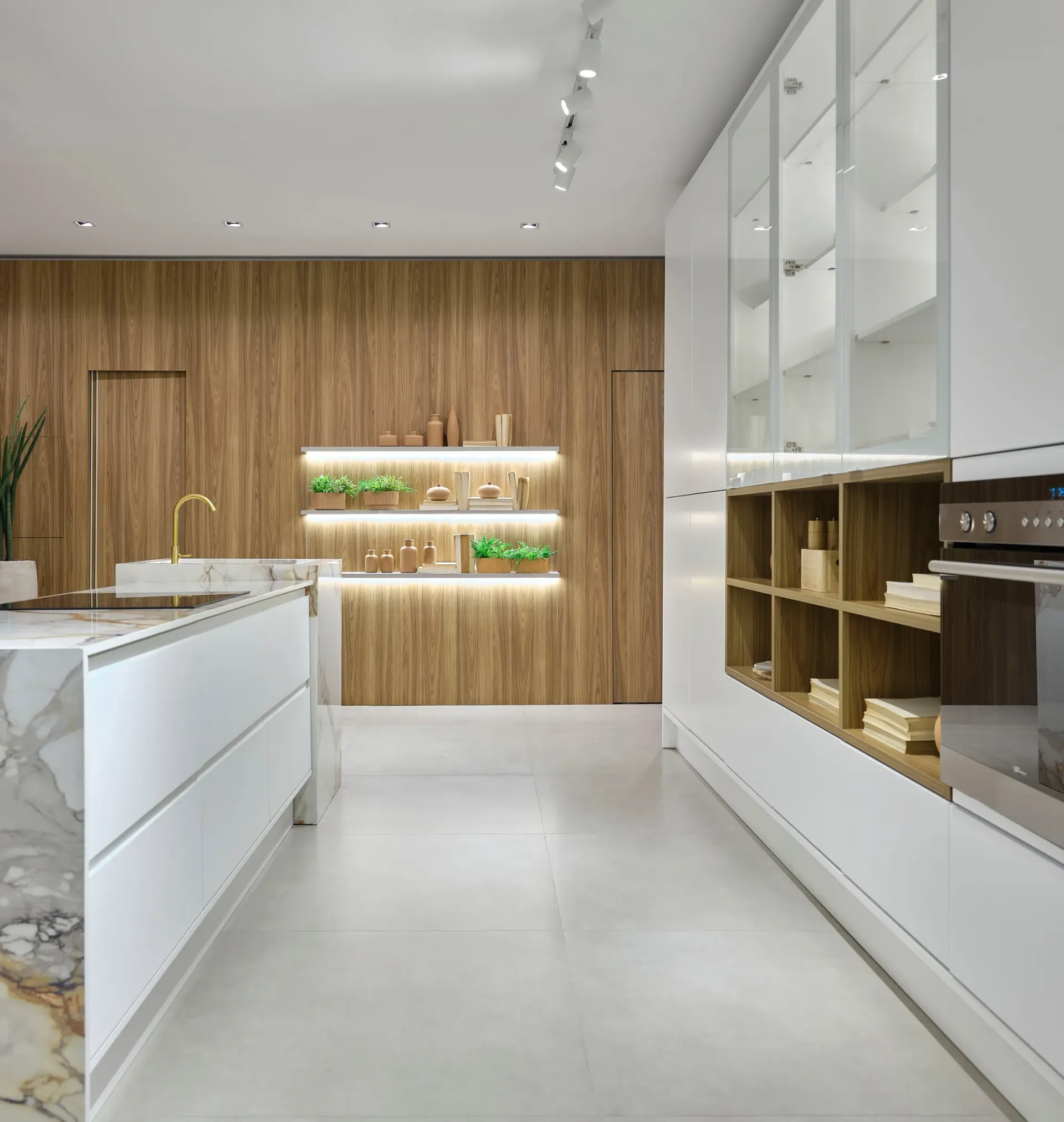 Cocina moderna blanca con pared decorativa de madera, estanterías empotradas y una elegante encimera tipo isla.