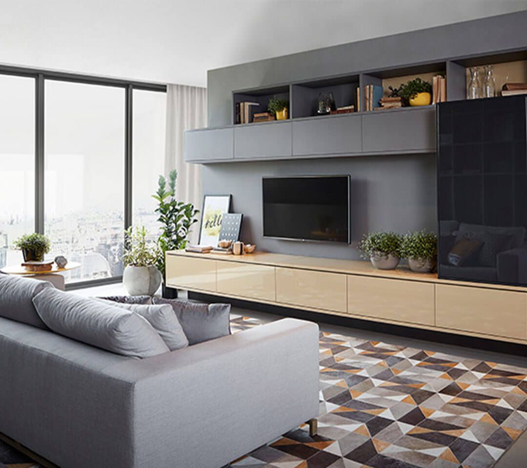 Una sala de estar con sofá, televisión y alfombra.