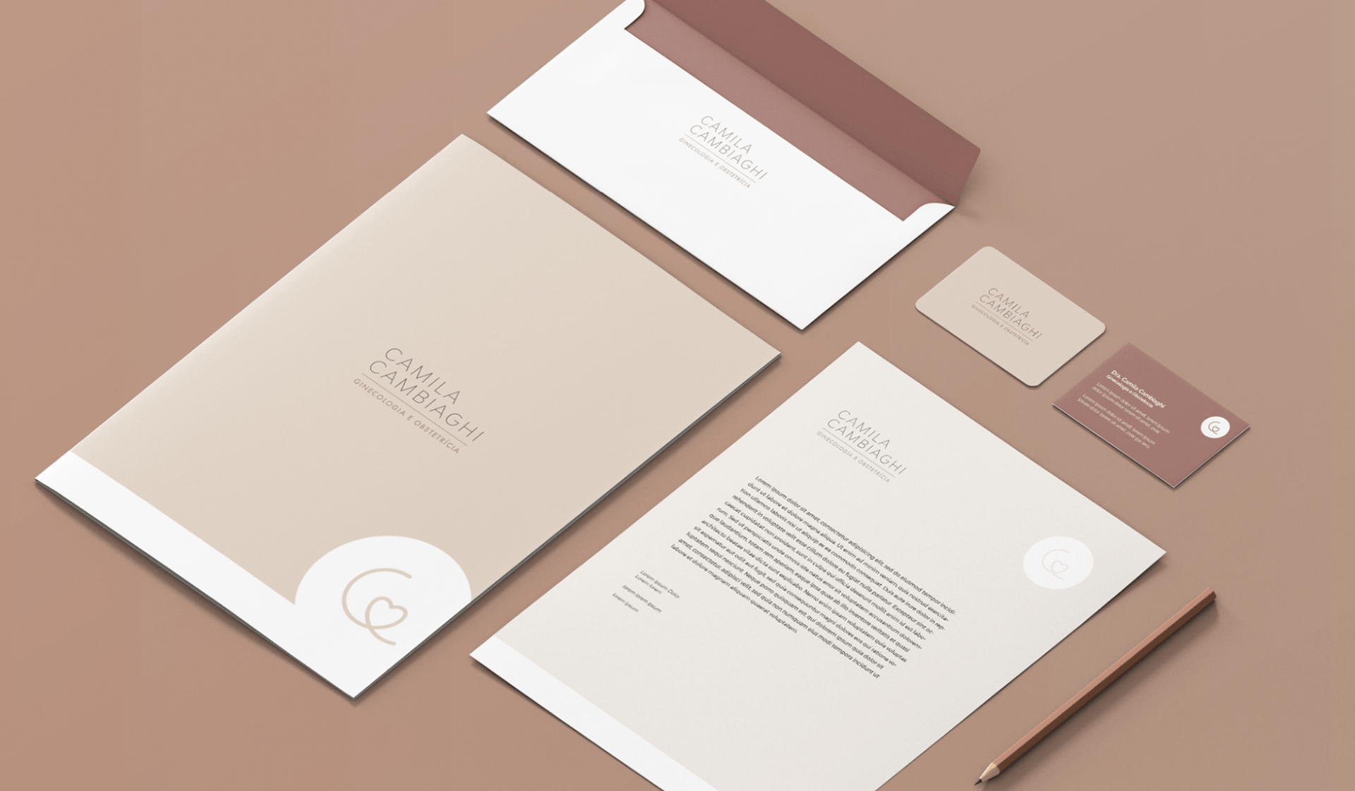 Um conjunto de envelope, papel timbrado, cartão de visita e caneta sobre uma mesa.