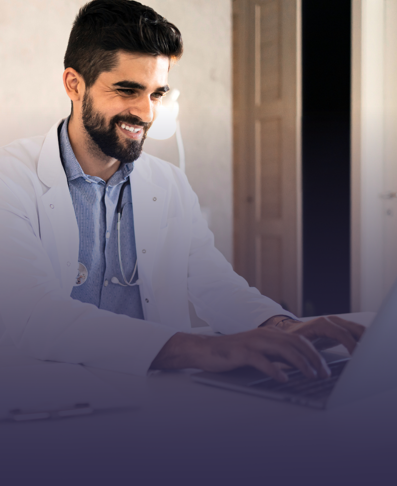 Um homem de jaleco está digitando em um laptop.
