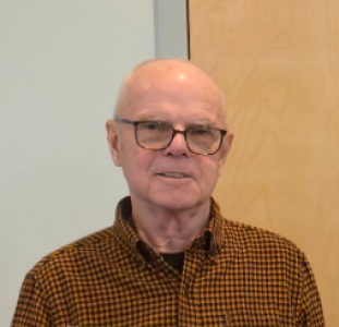 Silhouette of a person from the shoulders up, wearing a jacket and light shirt.