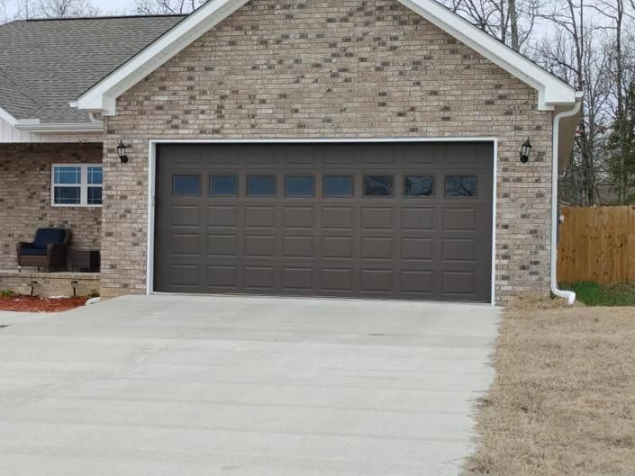 Suburban house with a dark two-car garage and a light concrete driveway