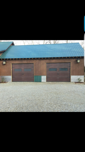 Brick garage with two brown doors and a blue metal roof