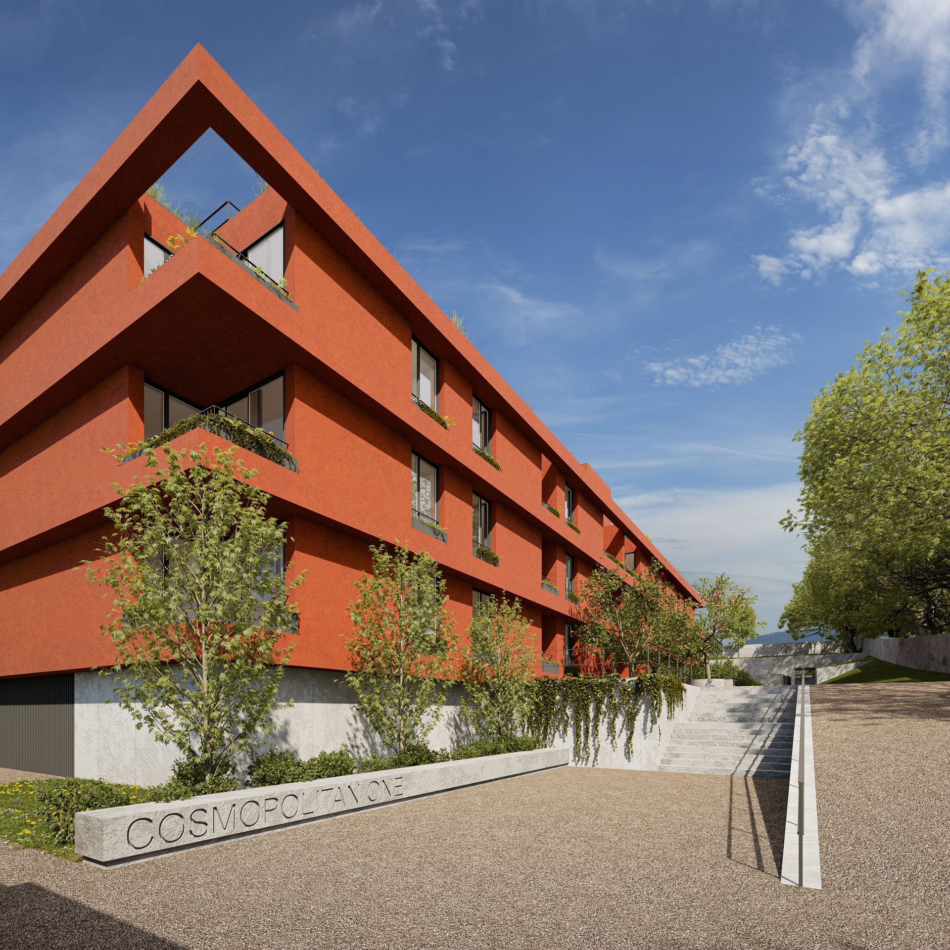 Edifício vermelho moderno com topo triangular, pequenas árvores e uma entrada de pedra em um dia ensolarado.