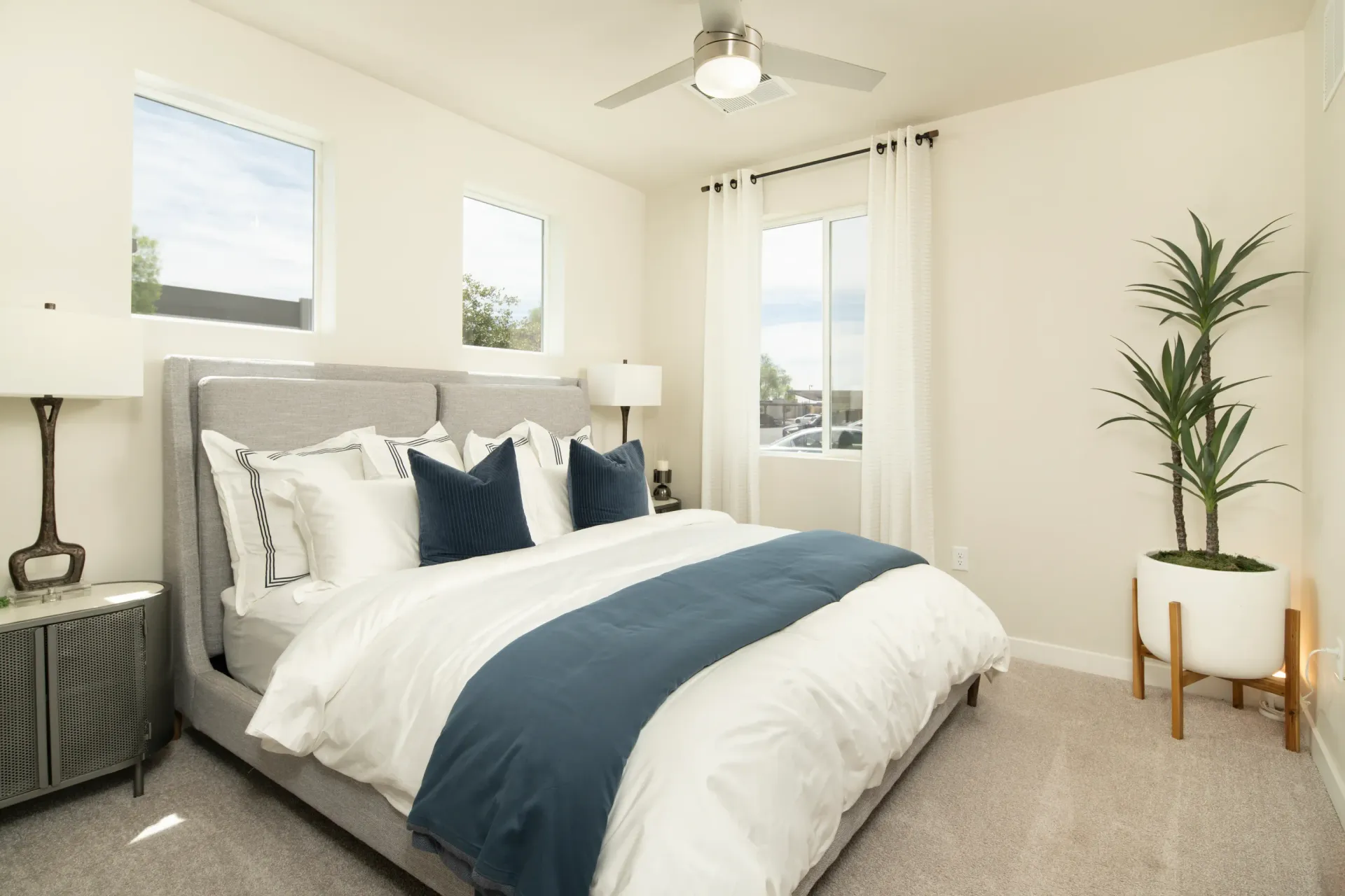 Spacious bedroom with a king-size bed, modern furniture, and natural light at Lumina Mountain Vista in Mesa, AZ.