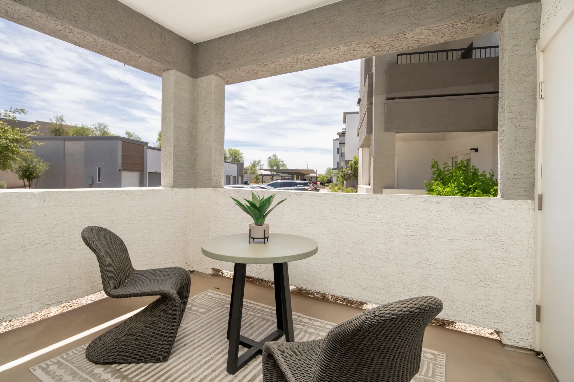 Balcony with two chairs and a table overlooking the community at Lumina Mountain Vista in Mesa, AZ.