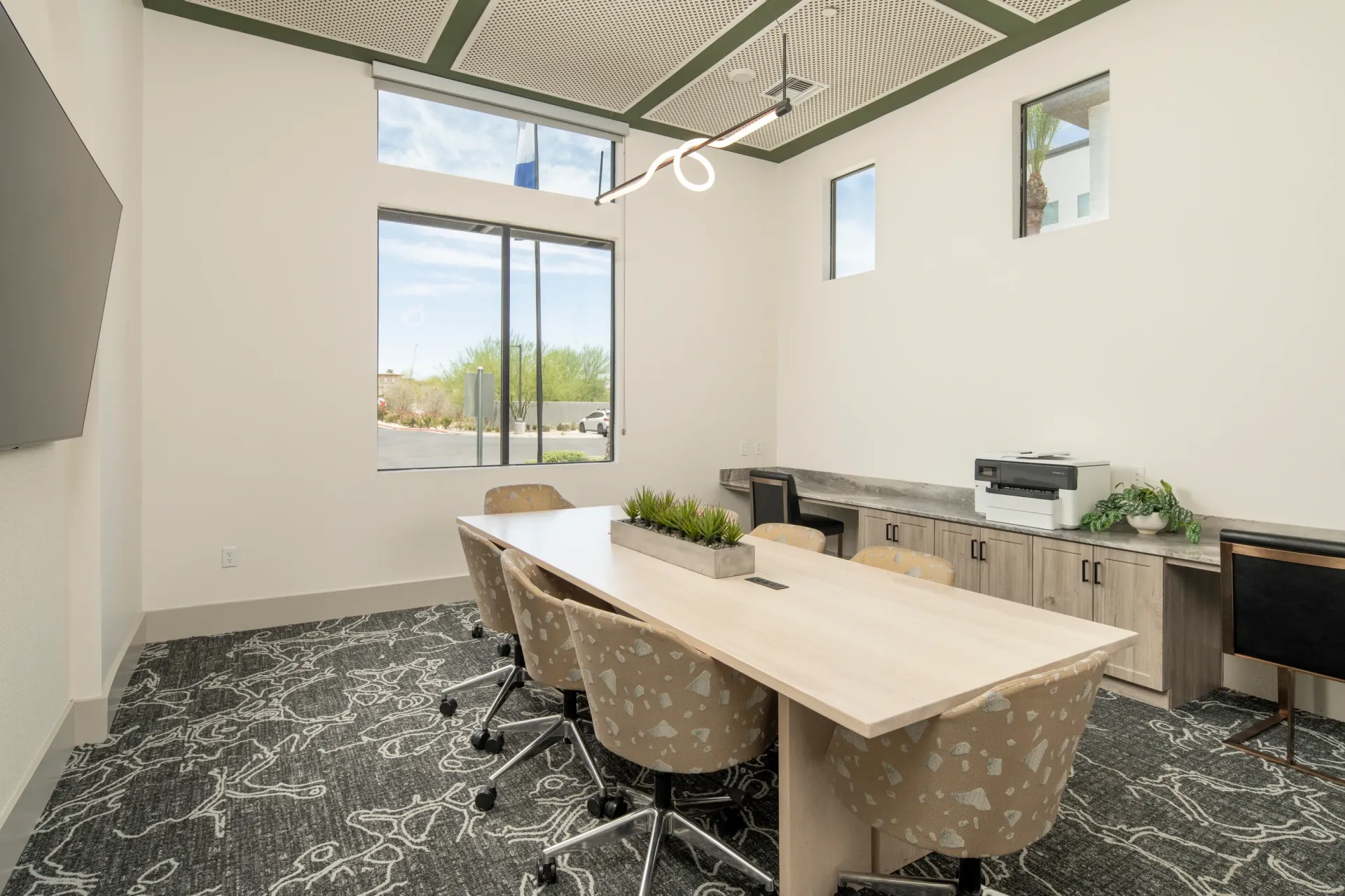 Conference room with a large table, chairs, and a printer at Lumina Mountain Vista in Mesa, AZ.