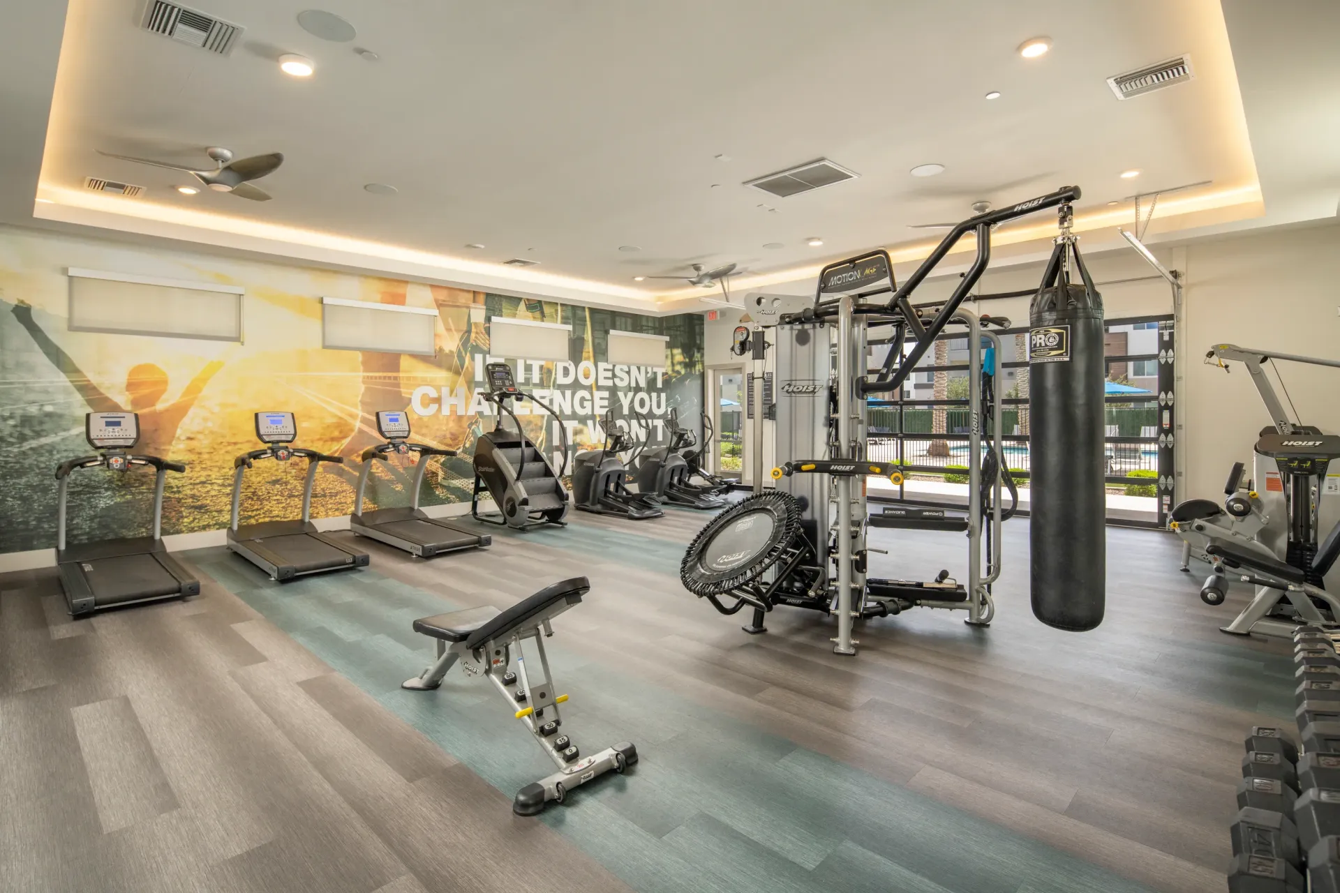 Treadmills, stair climbers, weight machines, and a punching bag in a modern fitness center at Lumina Mountain Vista in Mesa, AZ.