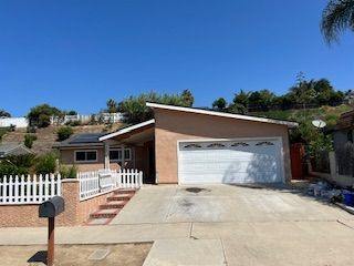 A house with a garage and a mailbox in front of it.