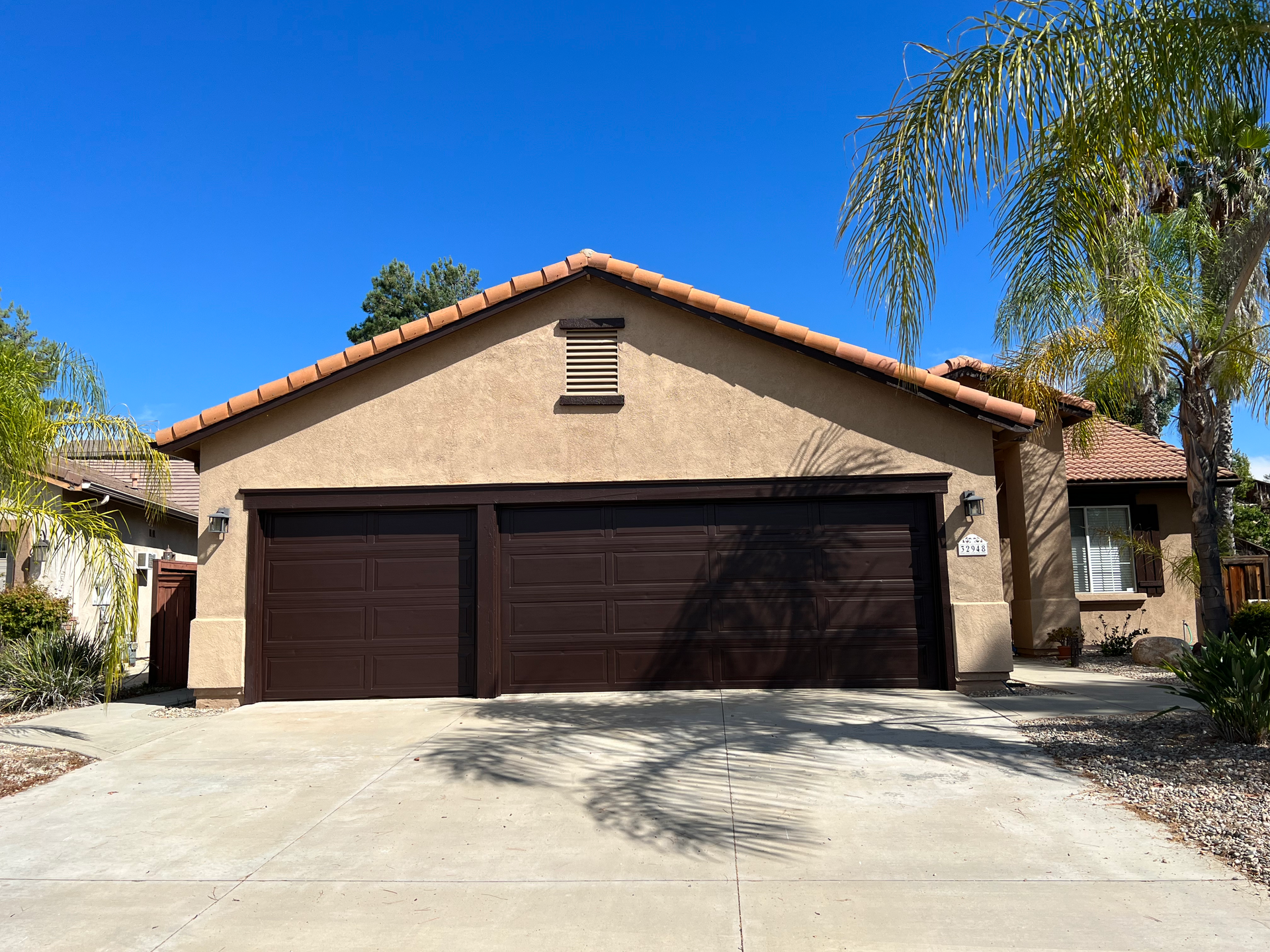 The front of a house with a brown garage door