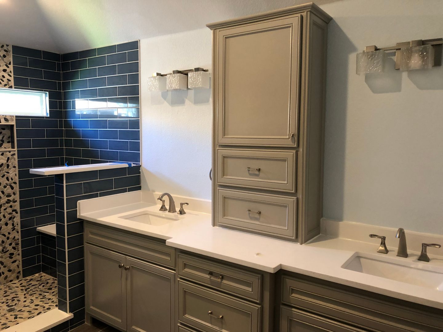 A bathroom with two sinks and a shower.