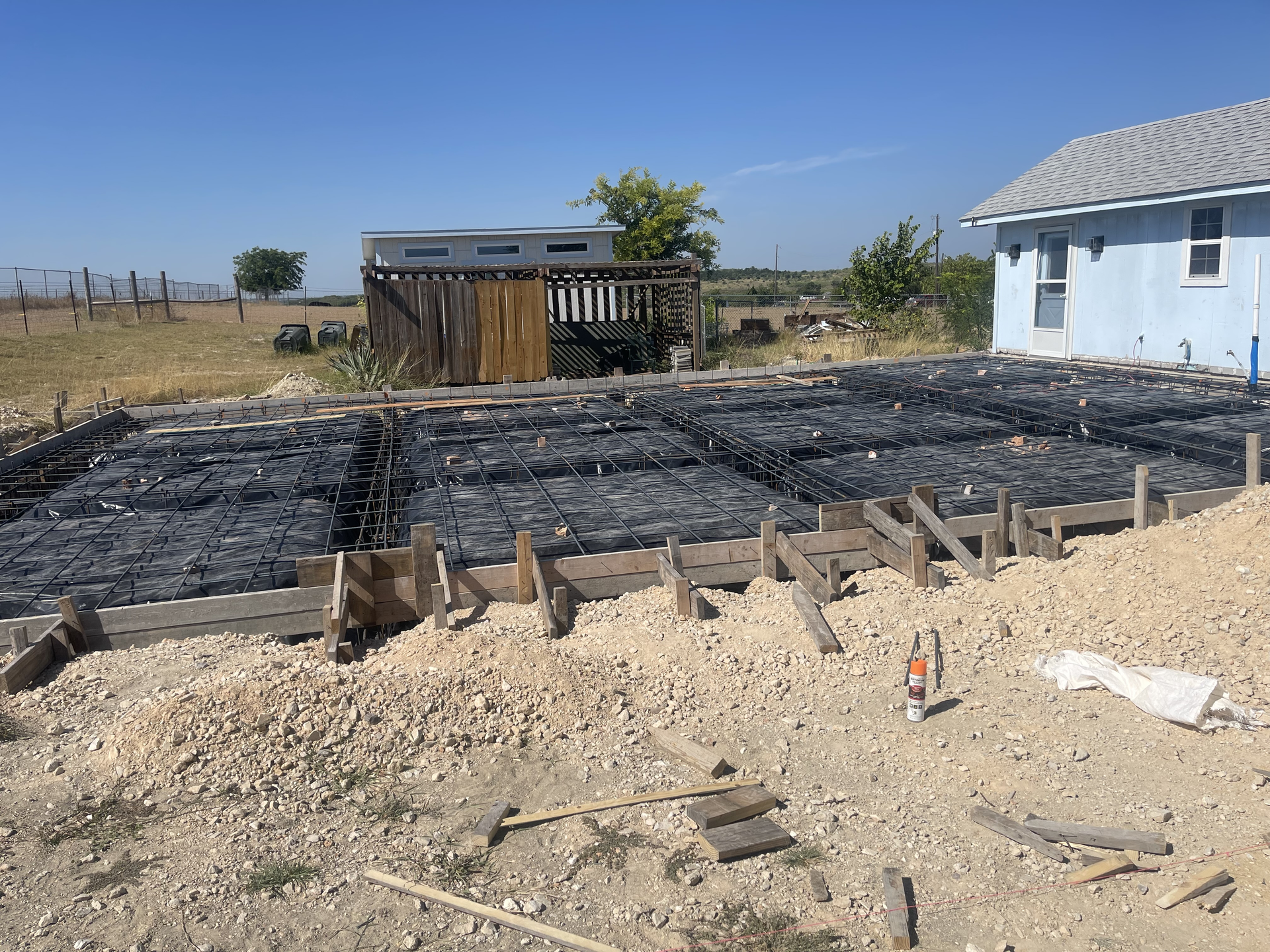 A house is being built in the middle of a dirt field.