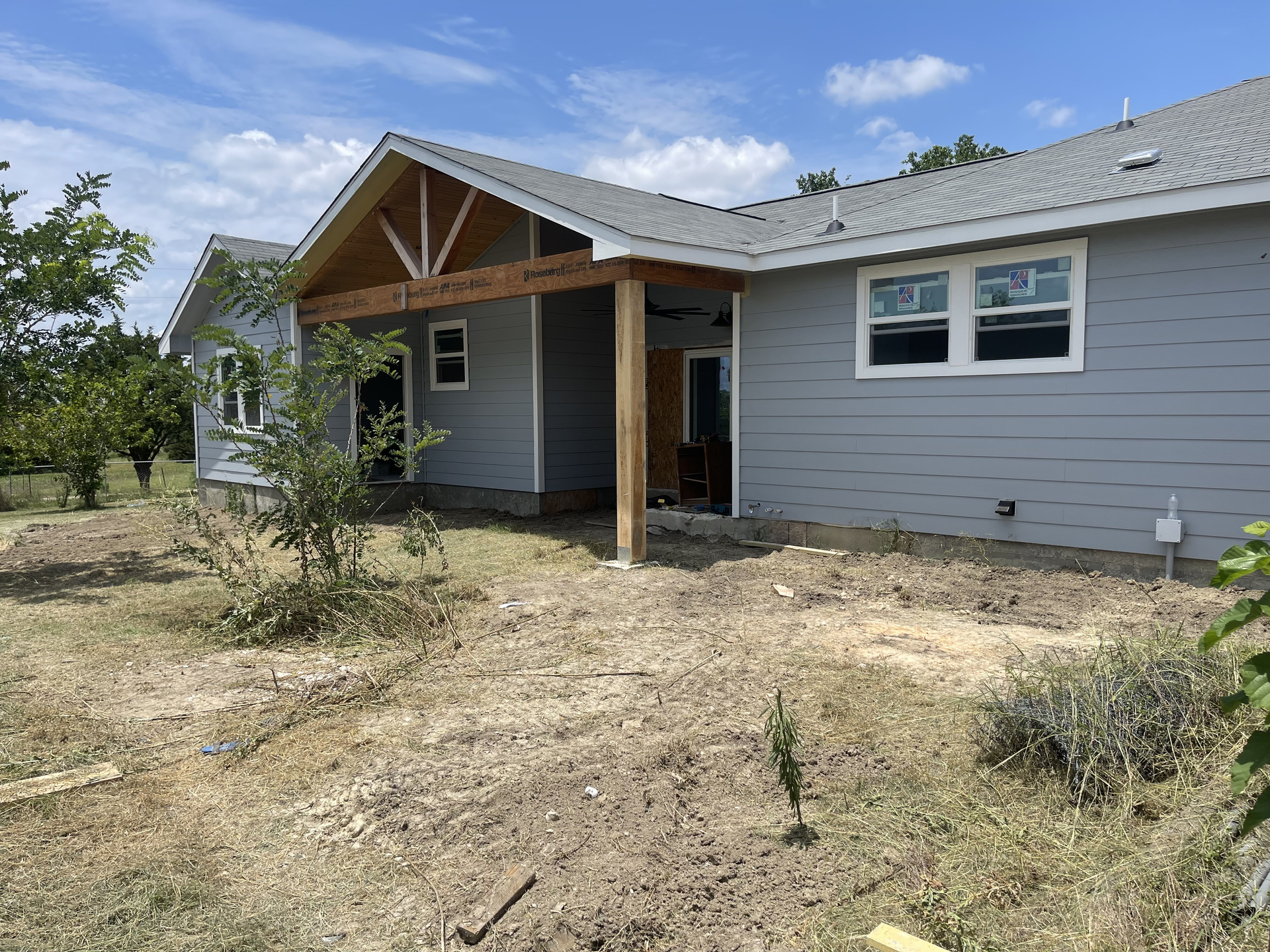 A house is being built in the middle of a dirt field.