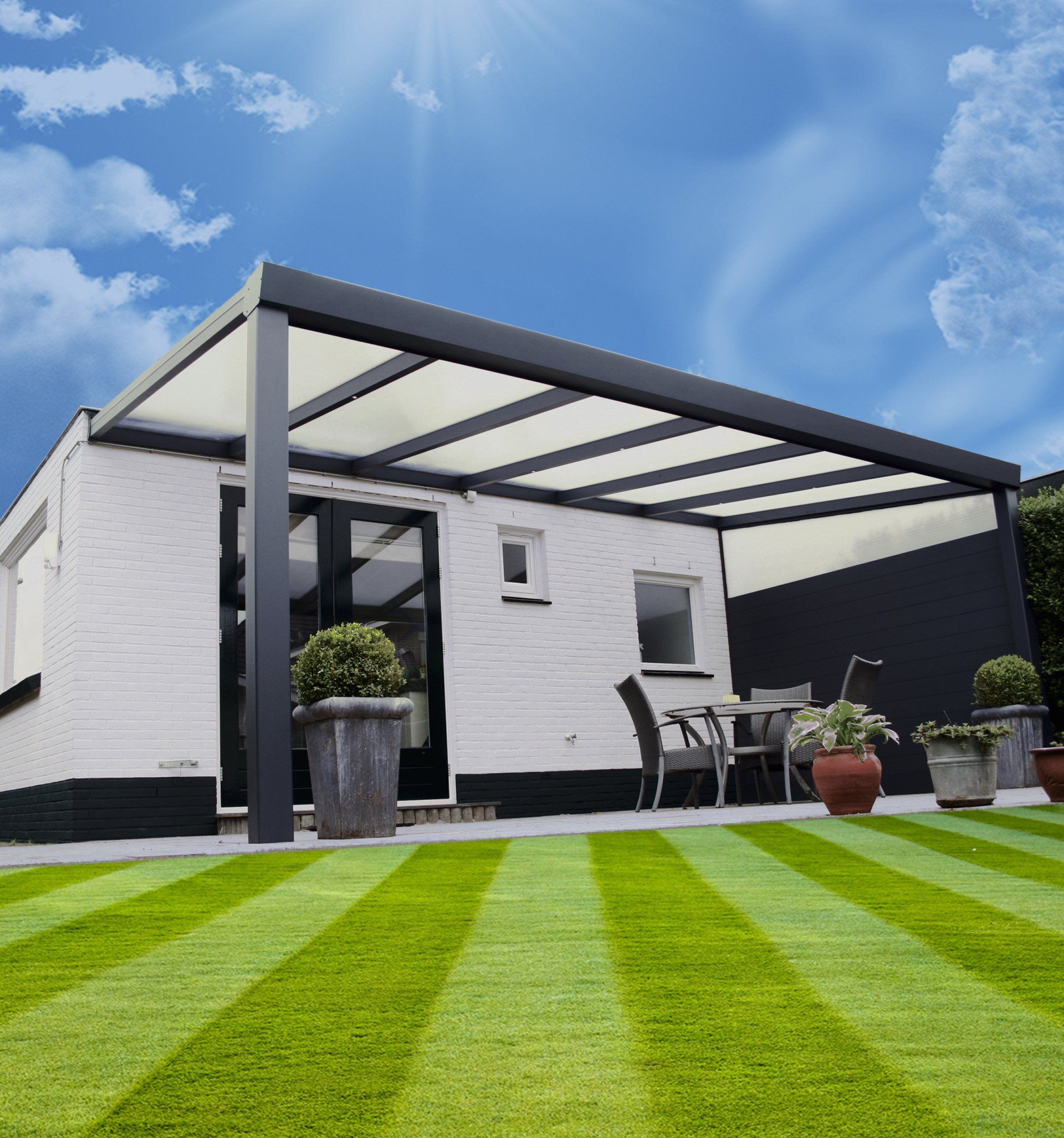 Ein Haus mit einer Pergola und einem gestreiften Rasen davor