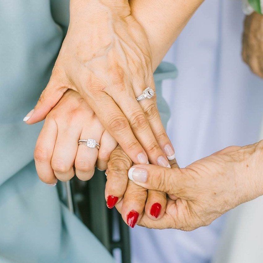 A woman with a ring on her finger is holding another woman 's hand