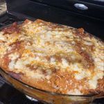 A casserole dish filled with food is sitting on top of a stove.