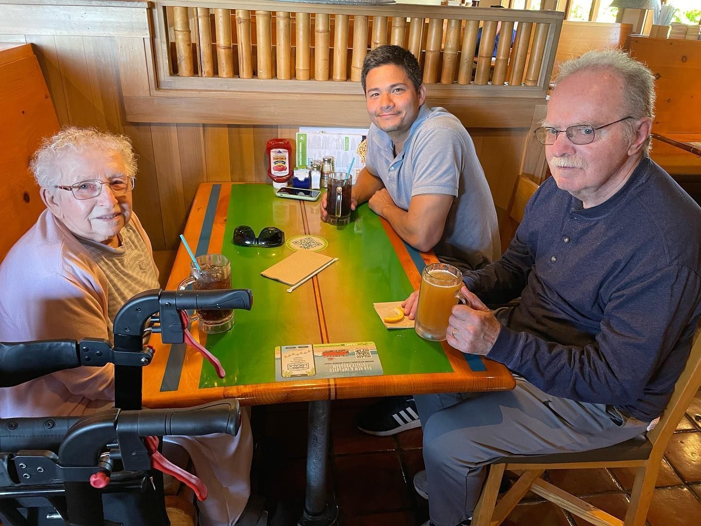 Three people are sitting at a table in a restaurant.