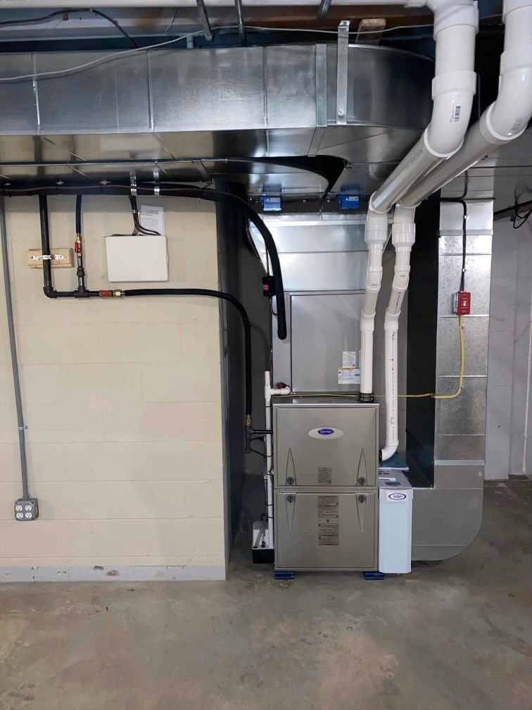 Technician inspecting a wall-mounted boiler in a basement utility room