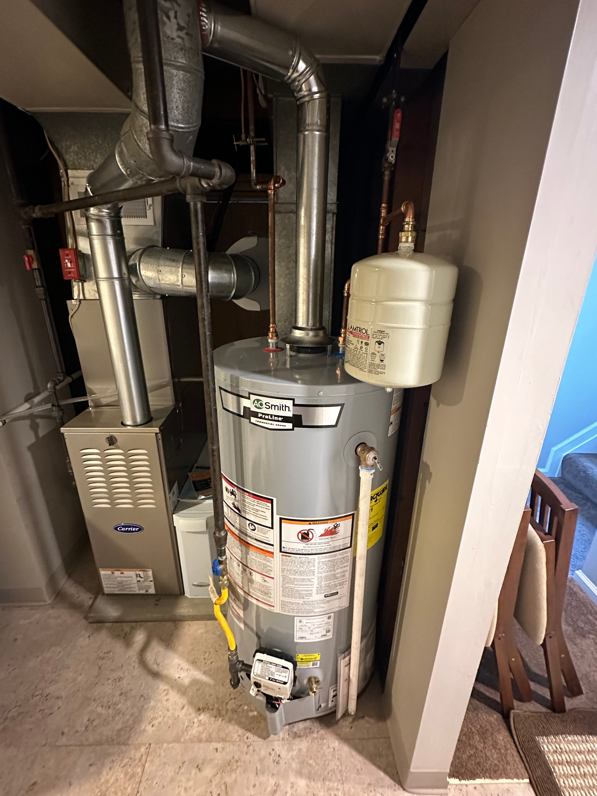 Water heater beside a metal storage rack with tools and supplies in a utility room.