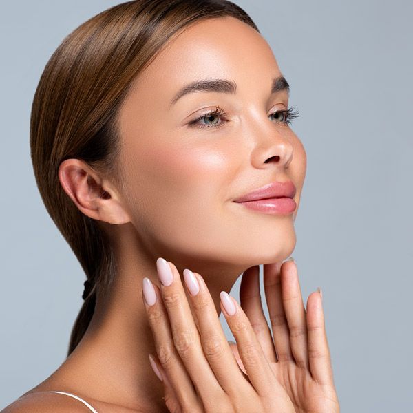 Woman applying skincare cream to her neck