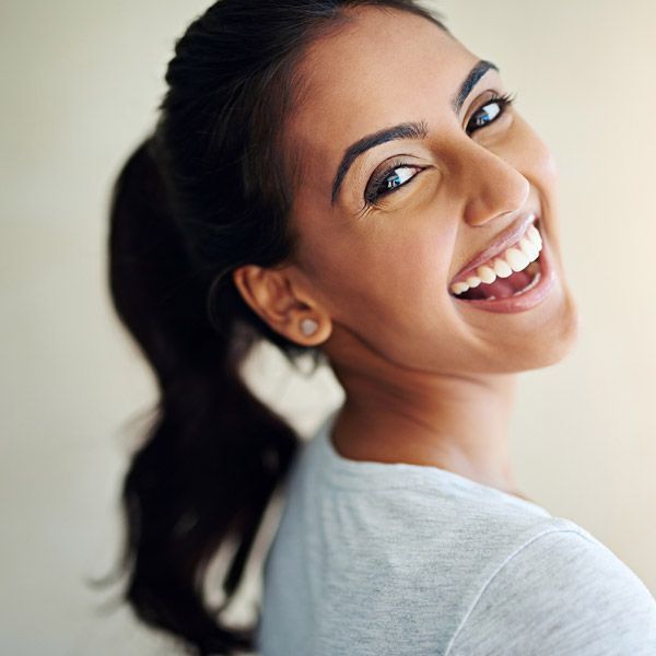 Smiling woman turning over her shoulder with a dark ponytail 