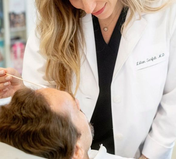 Dentist examining a patient’s mouth in a bright clinic, wearing a white coat and using a dental tool.