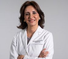 Smiling doctor in a white coat with arms crossed 