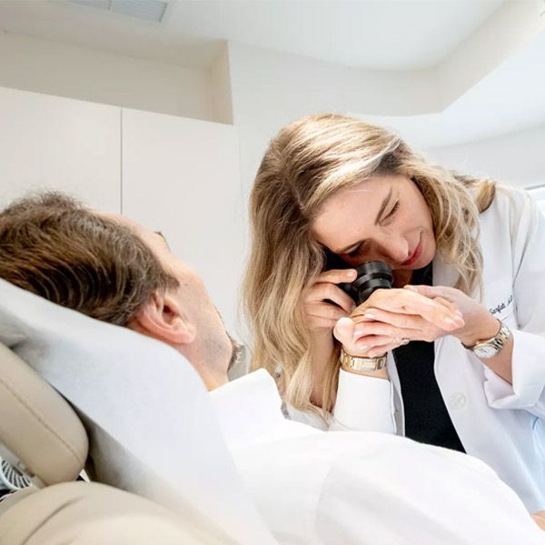 Doctor examining a patient’s eye with a magnifying tool in a bright clinic