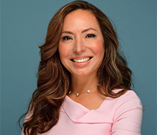 Smiling woman with long brown hair in a pink top
