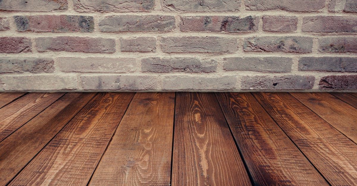 There is a wooden floor in front of a brick wall.