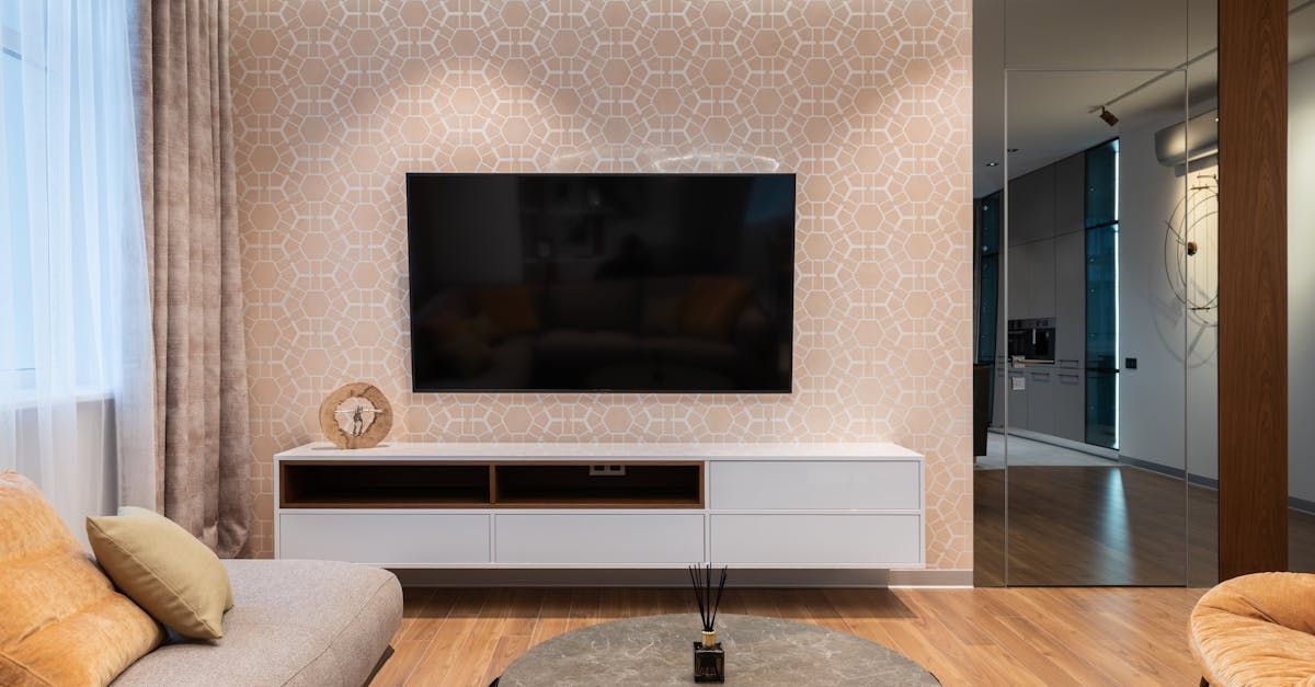 A living room with a couch and a flat screen tv on the wall.