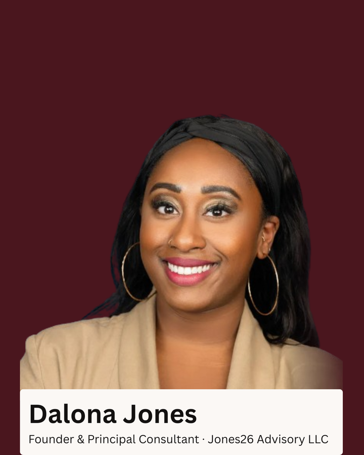 Portrait of Dalona Jones smiling against a burgundy background, wearing hoop earrings and a beige blazer