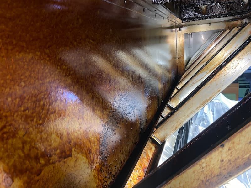 Stainless steel interior, likely a commercial kitchen. Reflective surfaces show angles and details.