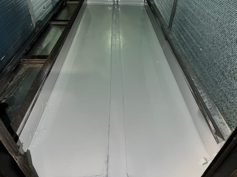 Long, light gray surface with a seam down the middle, flanked by dark frames and mesh.