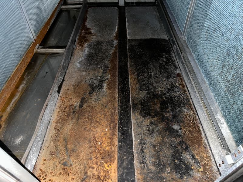 Rusty metal interior of an industrial structure, possibly a machine or walkway.