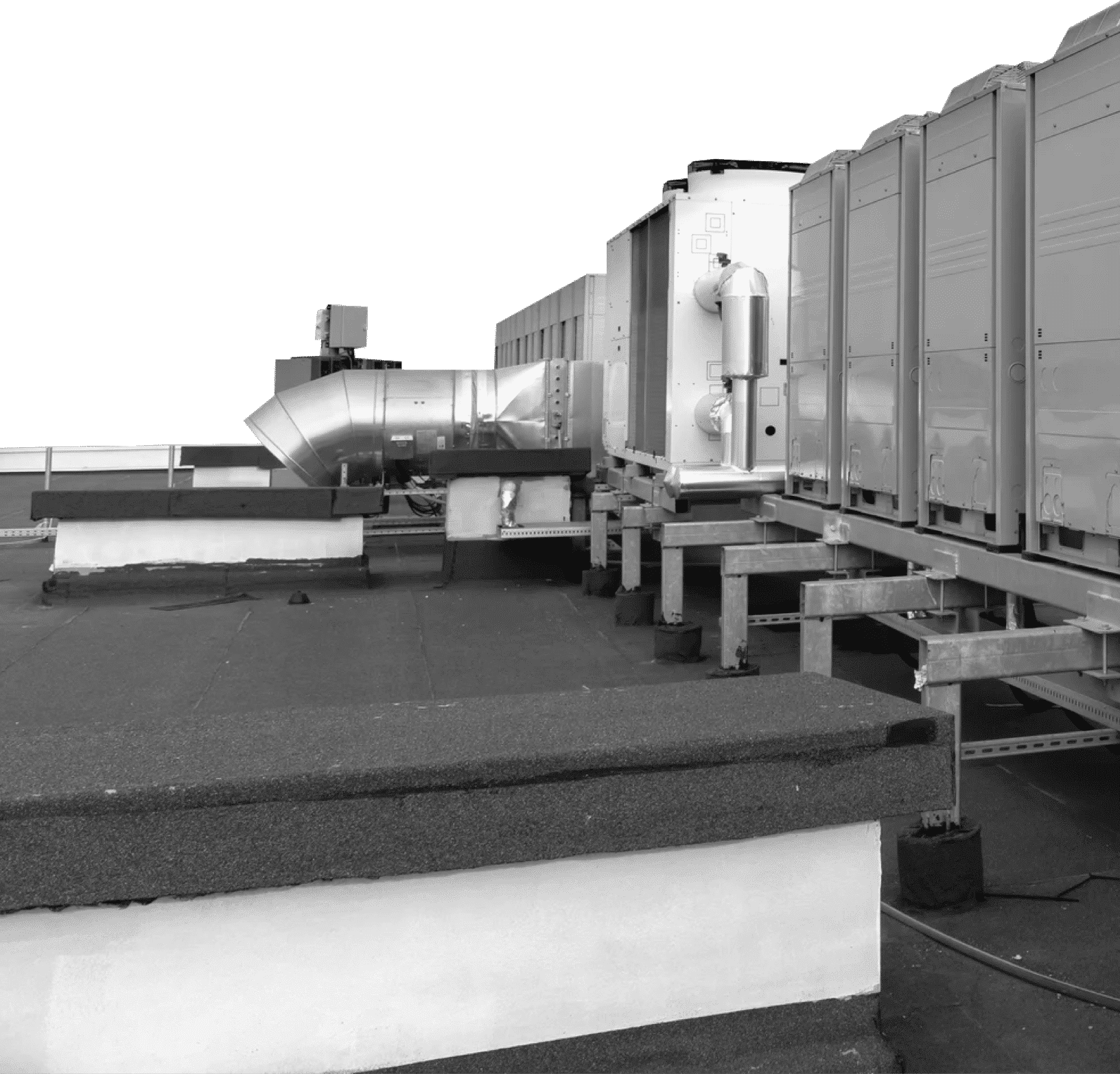 Rooftop HVAC units mounted on metal supports. Silver ductwork and rectangular units sit on a dark roof.