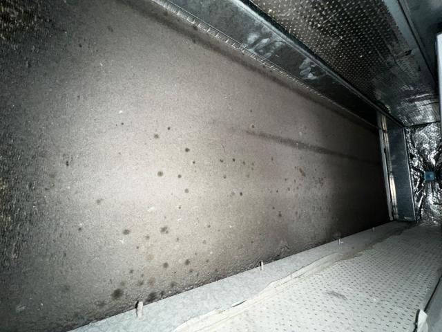 Inside of a dirty, gray metal HVAC duct.