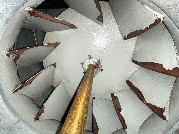 Fan blades inside a metal housing, with a central gold-colored rod.