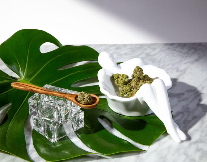 Marble tray with green leaf, glass spoon, and white dish of green herbal paste