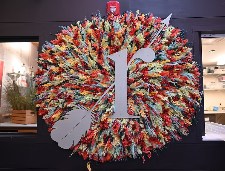 Colorful circular floral display with a large white “1” in a storefront window
