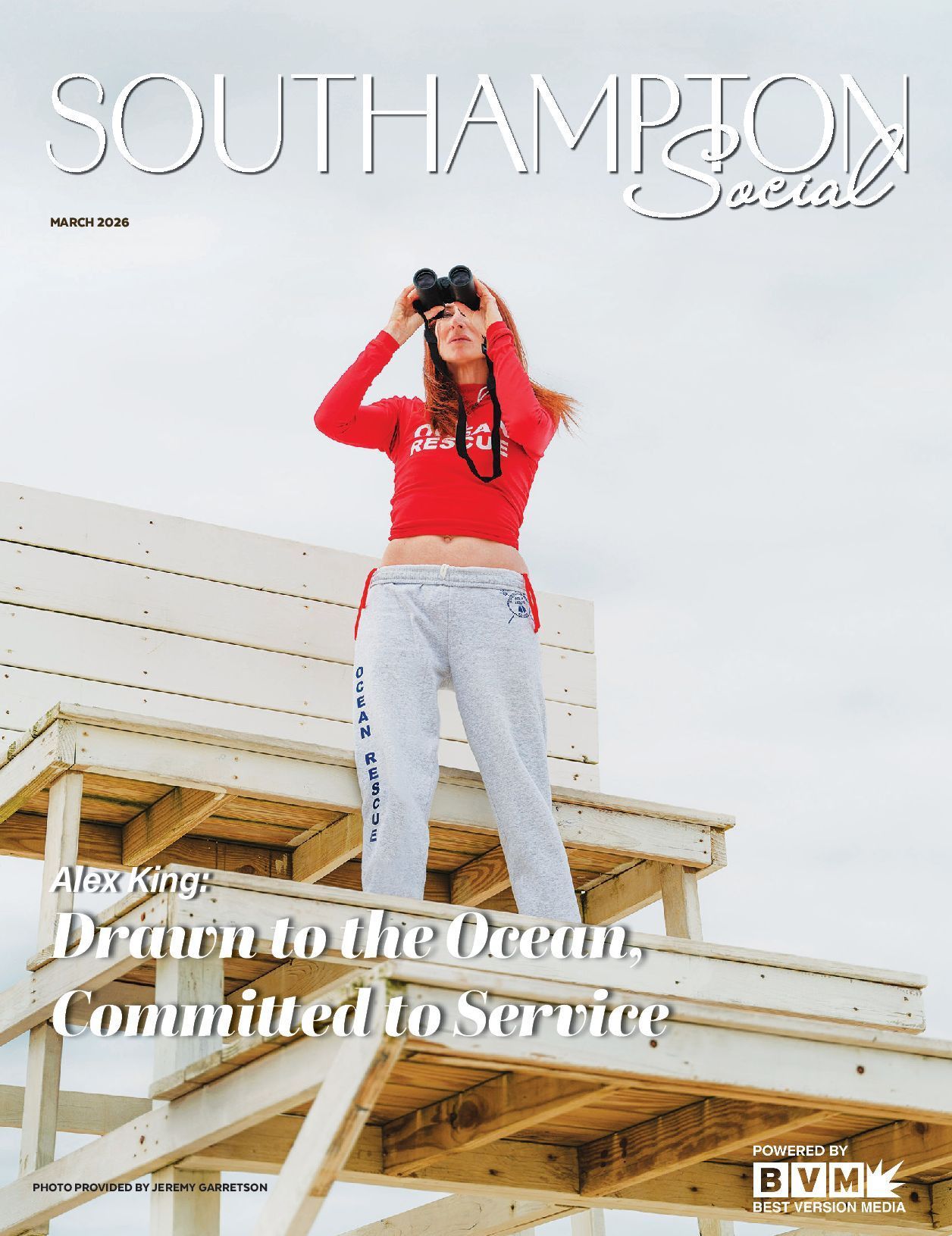 Woman in red sweater and gray pants standing on a rooftop by the ocean with text about Southampton