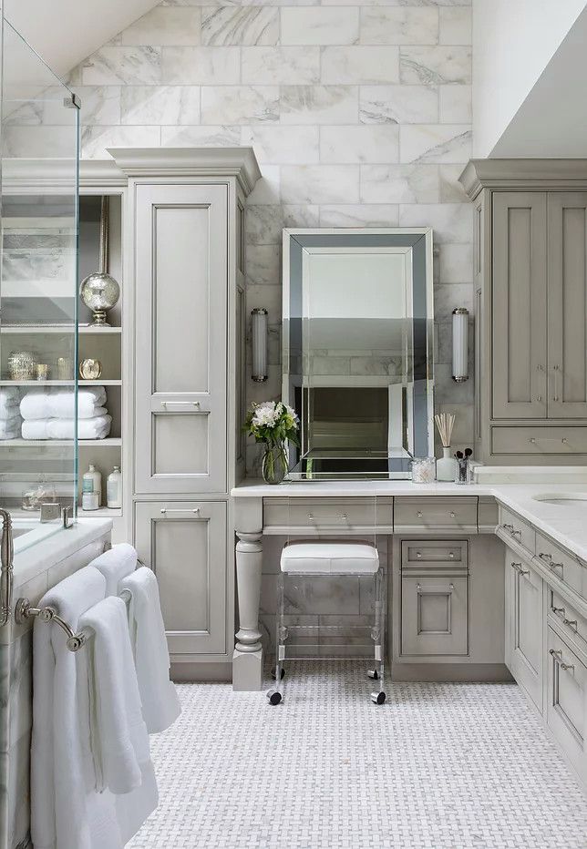 Elegant marble bathroom with vanity, mirror, sink, stool, and built-in cabinets