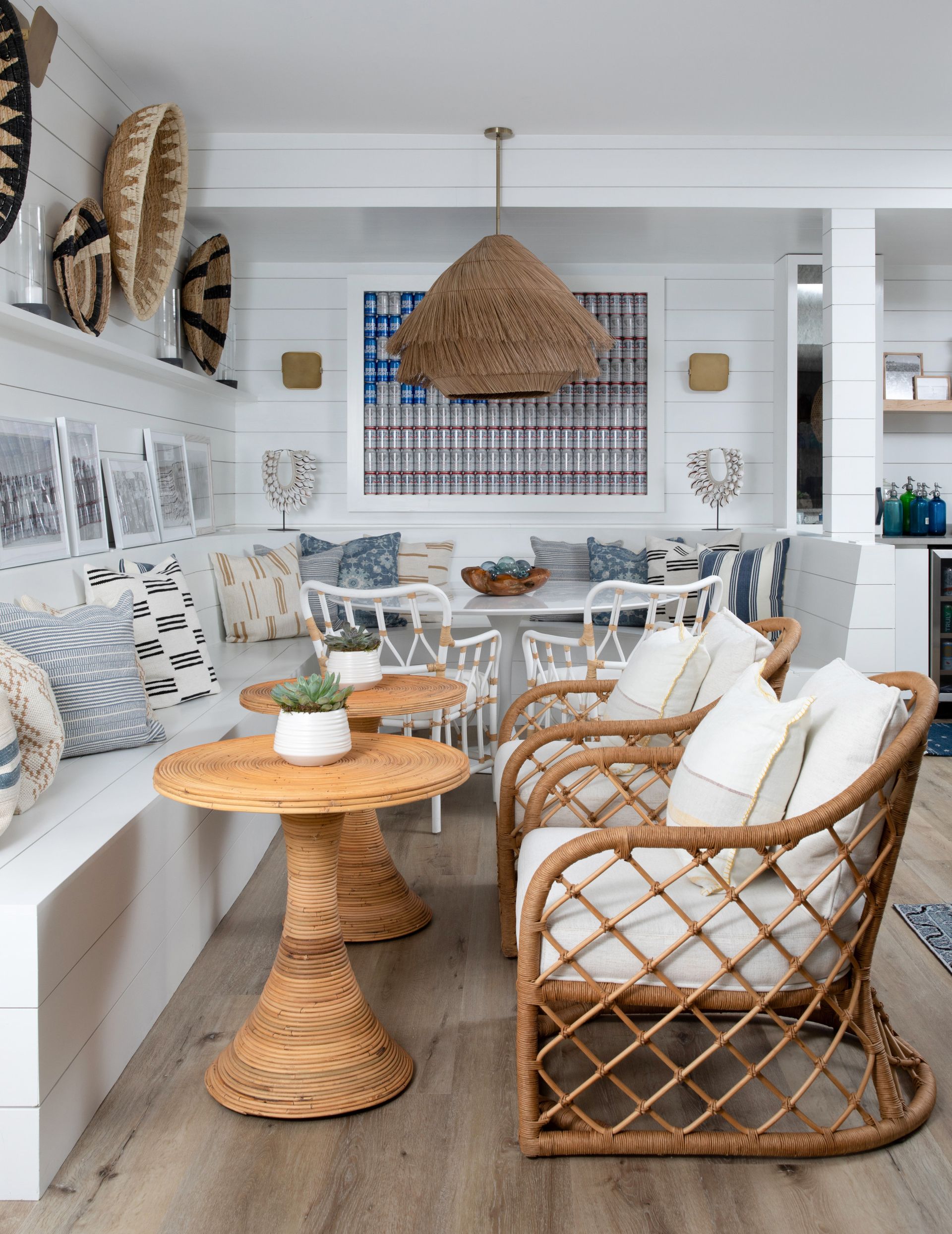 Bright coastal living room with wicker chairs, white decor, and a woven pendant lamp