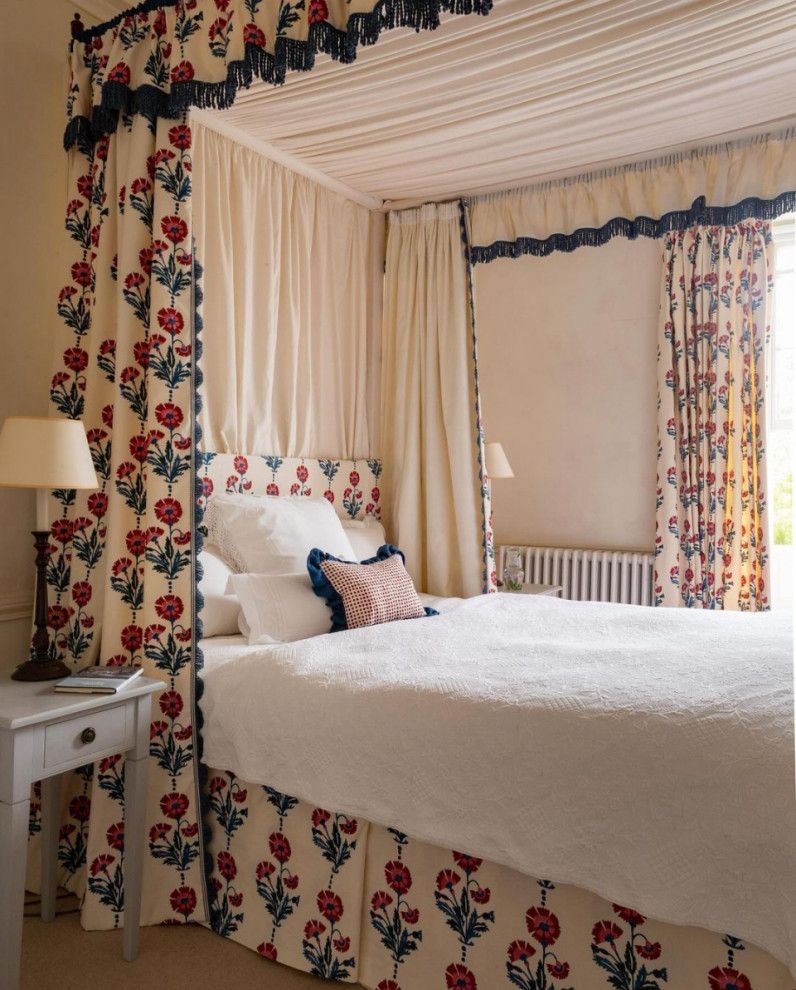 Floral four-poster bed in a cozy cream bedroom with matching curtains and bedside table